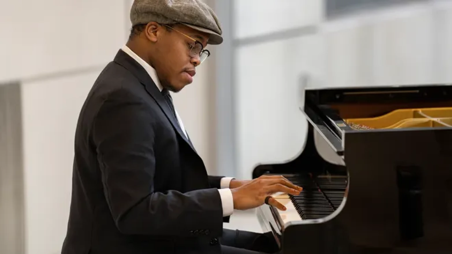 A man sits at and plays a piano. 